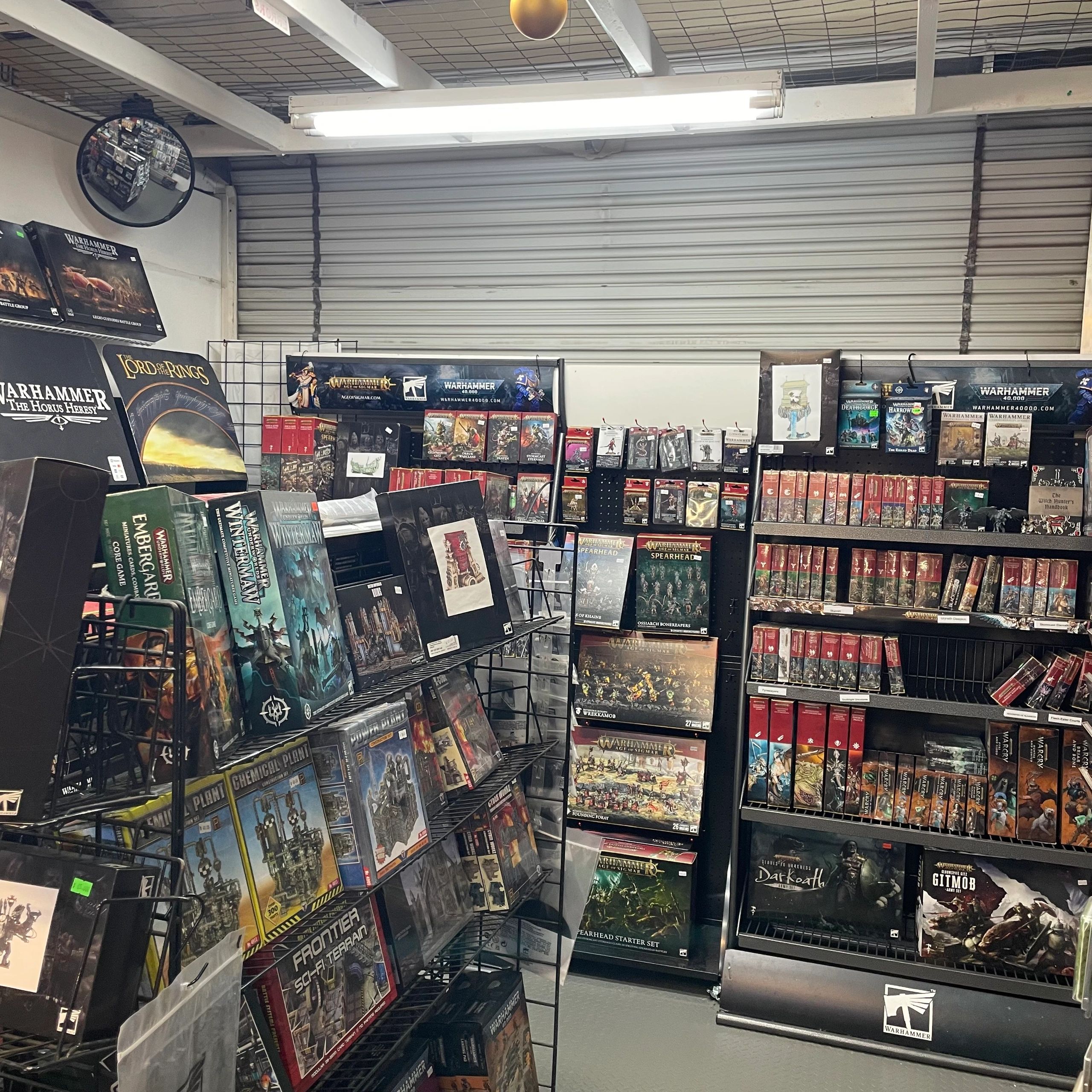 A hobby store corner filled with Warhammer and fantasy game boxes and miniatures