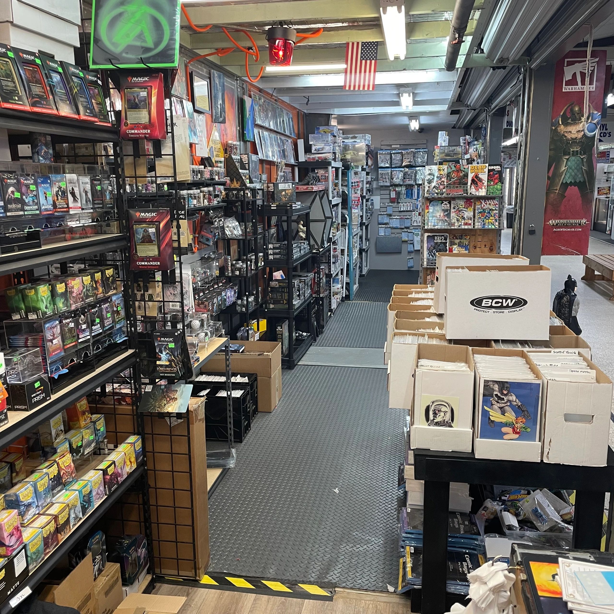 Inside a collectible card and comic book store with various merchandise and American flag.